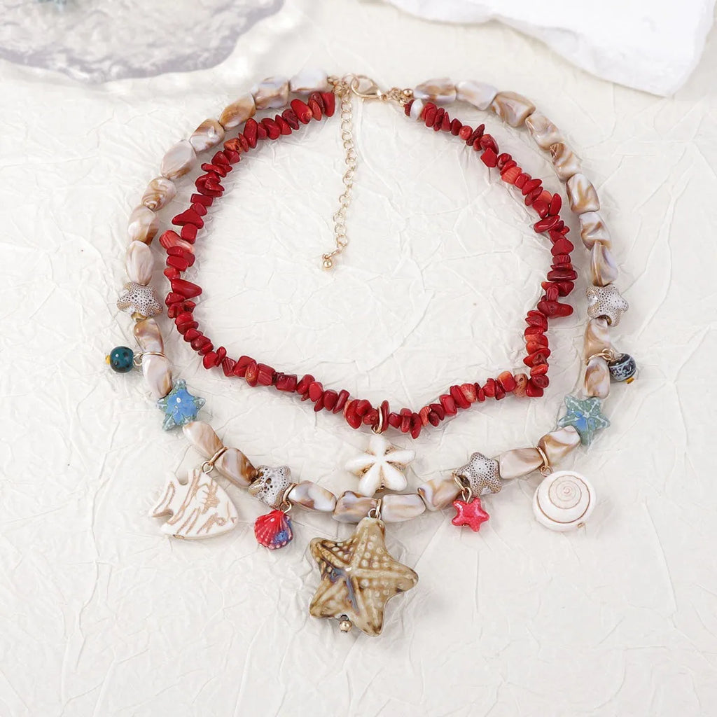 Gold marine life clavicle chain with conch shell and starfish pendant on display