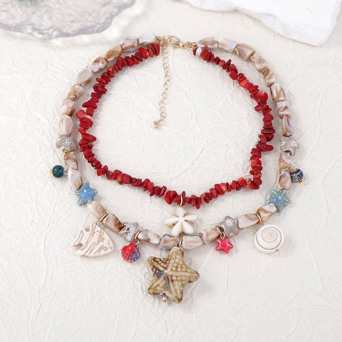 Gold marine life clavicle chain with conch shell and starfish pendant on display