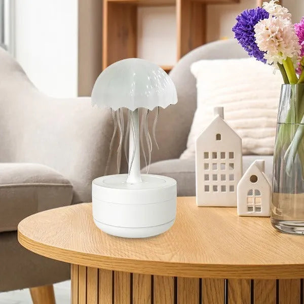 White jellyfish-shaped humidifier and essential oil diffuser with colourful night light on a desk.