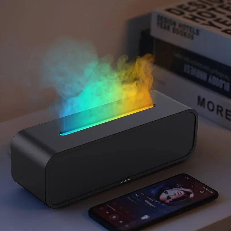 Black and white essential oil diffuser with flame effect and colour-changing lights next to remote control