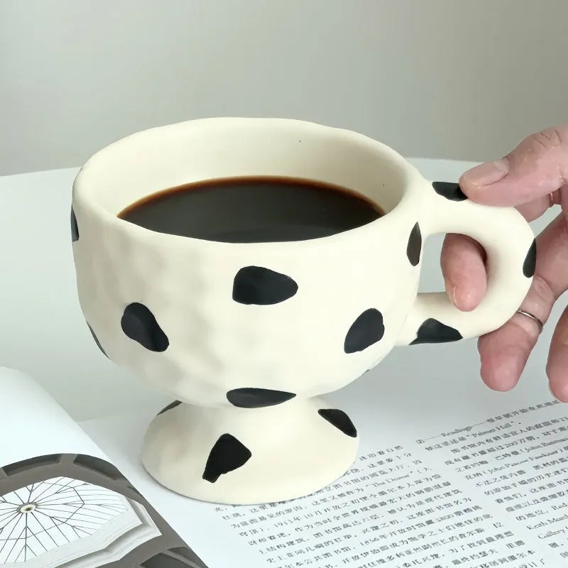 Hand-pinched irregular shaped ceramic mug in a solid colour, showing its unique form.