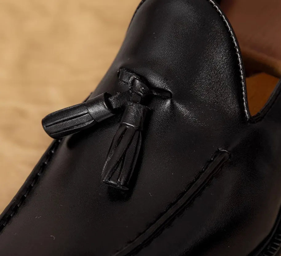 Men's black genuine leather slip-on loafers with a fringed design and rubber sole.