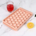 Blue silicone ice cube tray with lid showing 33 round compartments