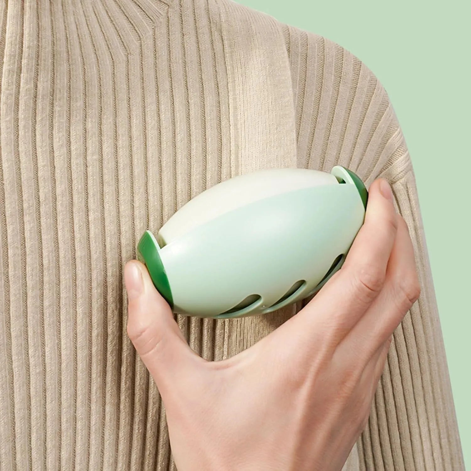Green and white reusable gel lint roller ball for pet hair removal on fabrics