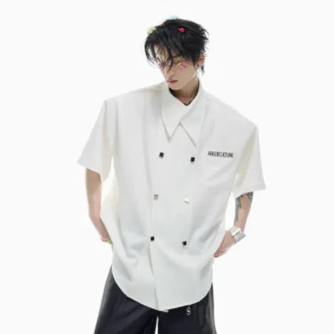 A man's loose-fit short-sleeve casual shirt with splicing detail and metal decoration on a hanger.