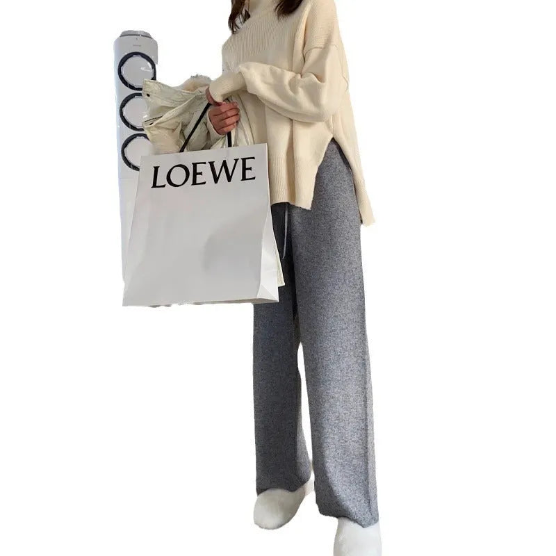 Women's high-waist knitted wide-leg trousers in cream white, showing straight-leg cut and drooping hem.
