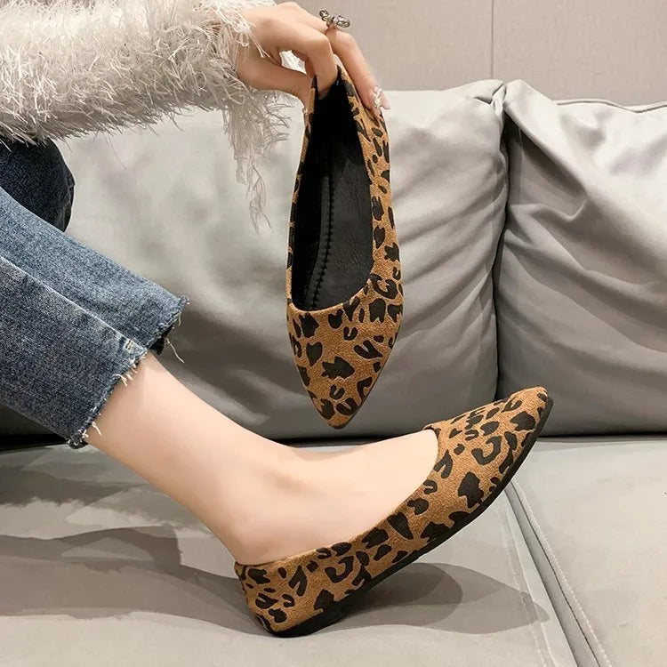 Women's flat pointed toe leopard print pumps with a low heel on a plain background.