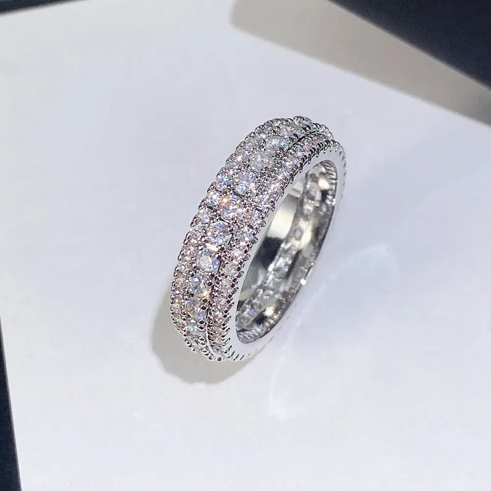 Geometric triangular ring with a zircon stone inlay, shown in white gold, yellow gold, and white and black finishes.
