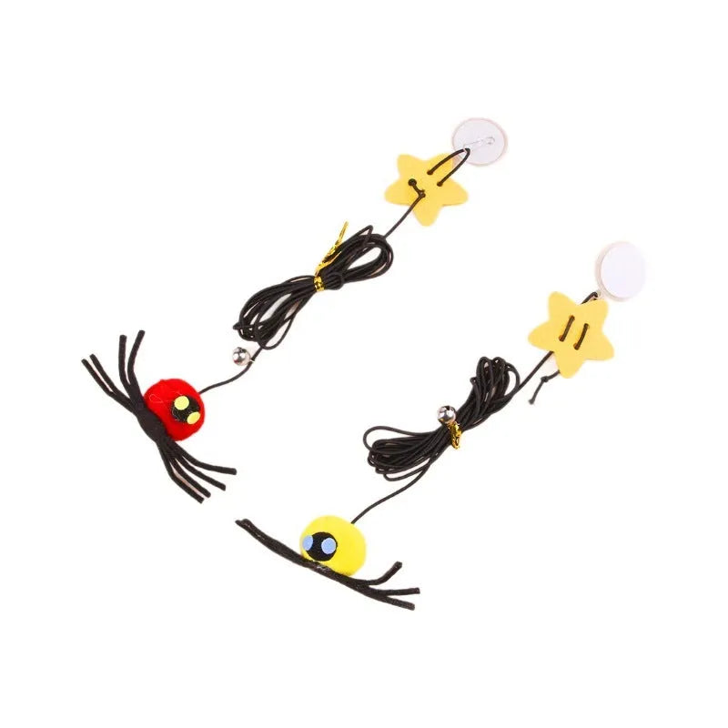 Red and yellow cat toy with feather and bell spider hanging from a door on an elastic rope.