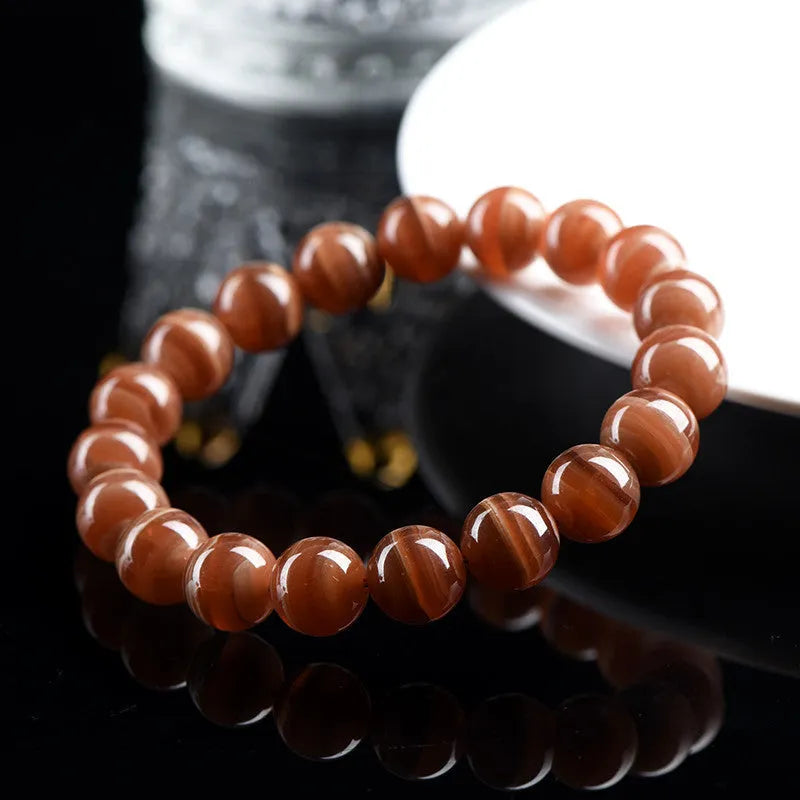 Natural pink old mine rhodochrosite round bead bracelet with a silver Ruyi charm.
