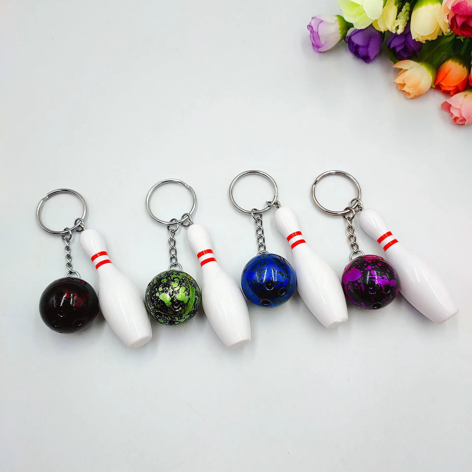 Mini bowling ball keychain pendant in PVC metal available in four colours: dark red, blue, purple, green