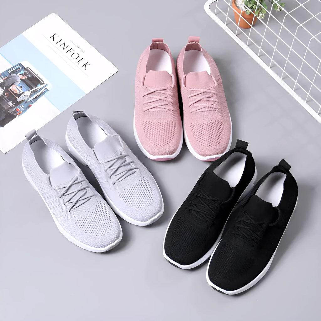Women's black mesh casual sneakers with lace-up front and round toe on a grey background.