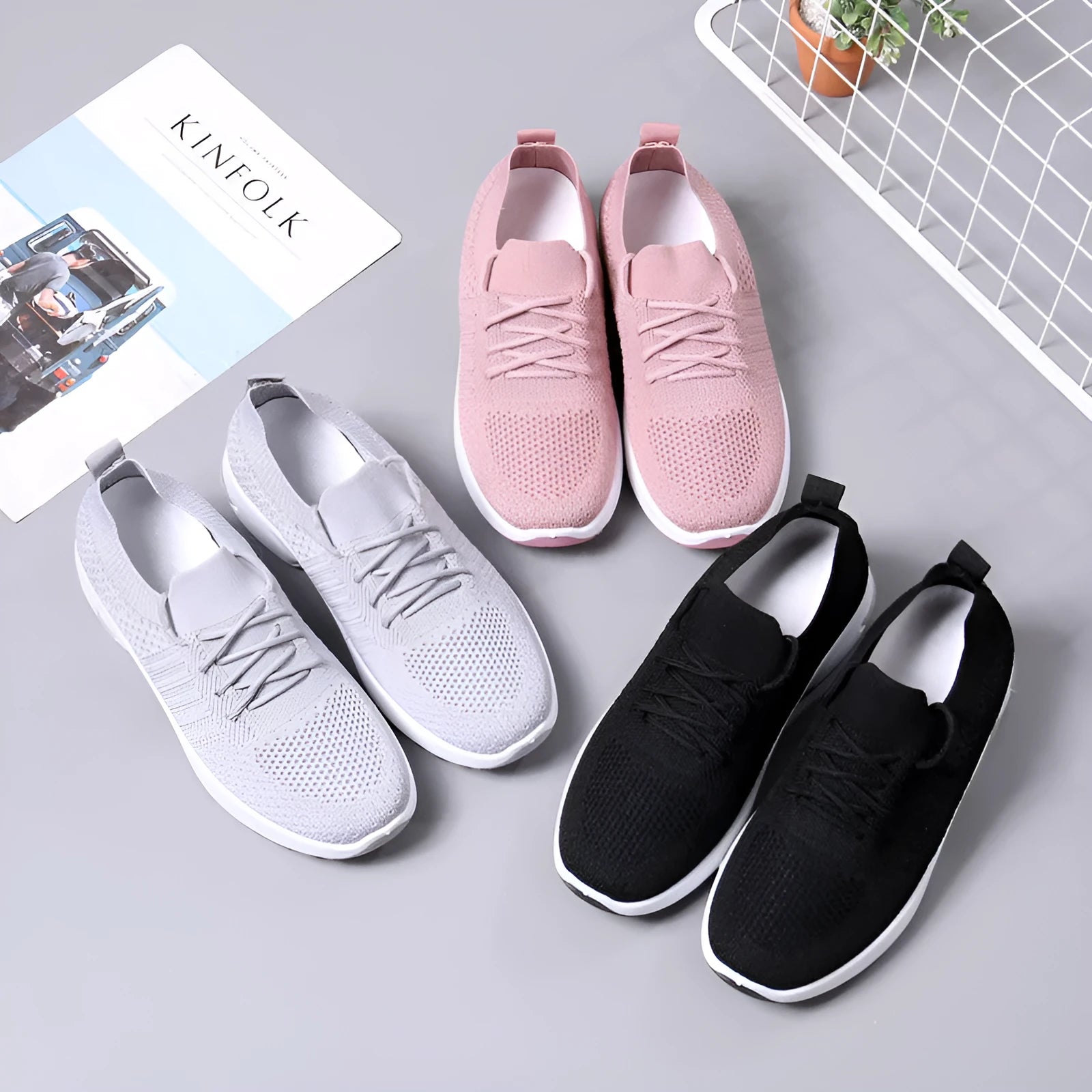 Women's black mesh casual sneakers with lace-up front and round toe on a grey background.