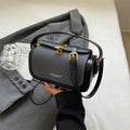 Women's black PU leather messenger bag with contrast stitching and a lock detail.