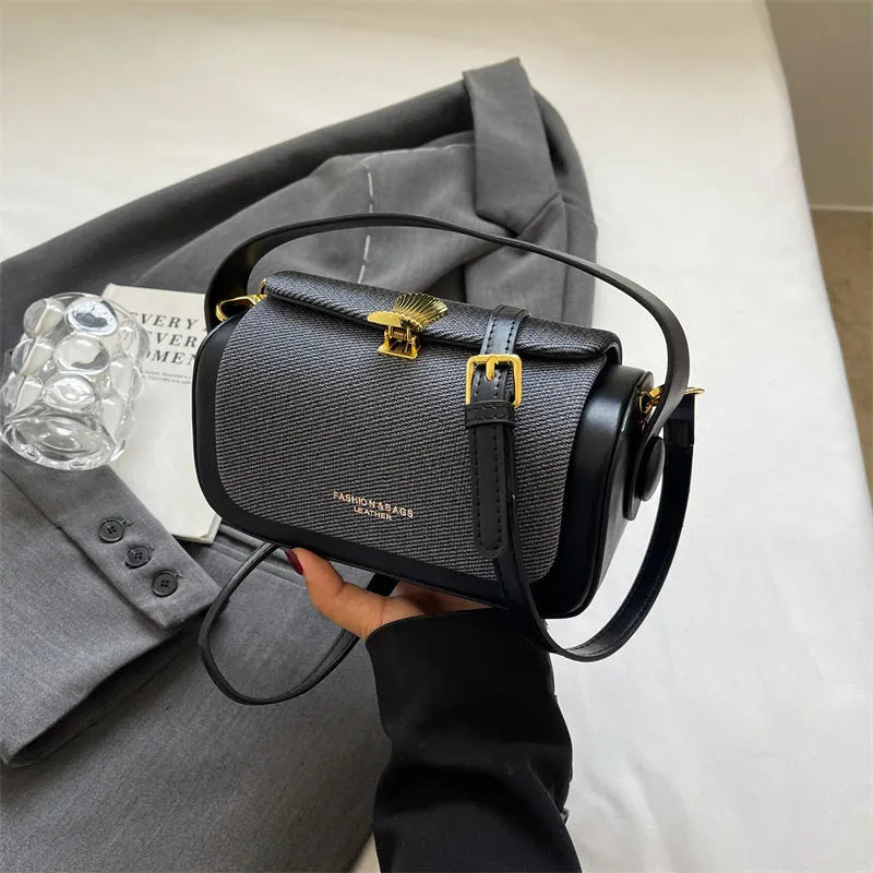Women's black PU leather messenger bag with contrast stitching and a lock detail.