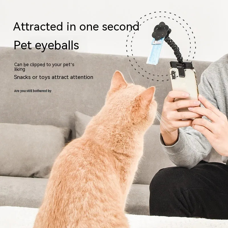 Black plastic pet photography clip holding a phone, with a rotating arm to grip dog or cat treats for photos.