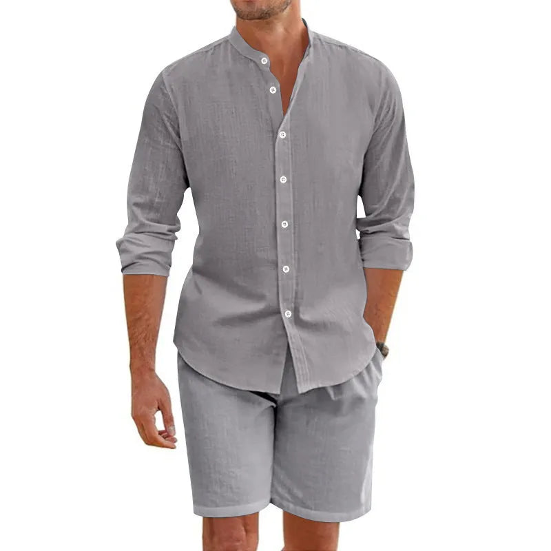 Man wearing a dark grey short-sleeve lapel shirt and matching drawstring shorts from a hemp-blend linen summer suit set.