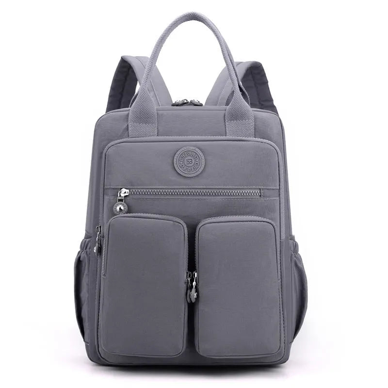 Large soft nylon waterproof backpack in grey, open to show internal laptop, camera, and phone compartments.