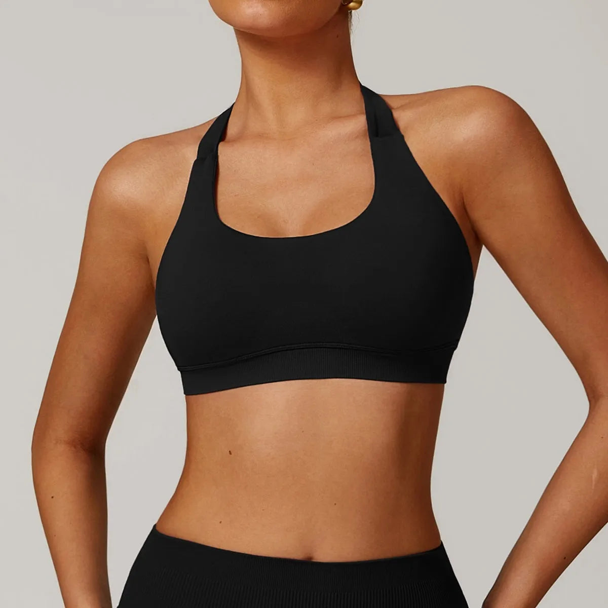 Women's black halter neck sports bra with hollow cutout design and medium support for yoga