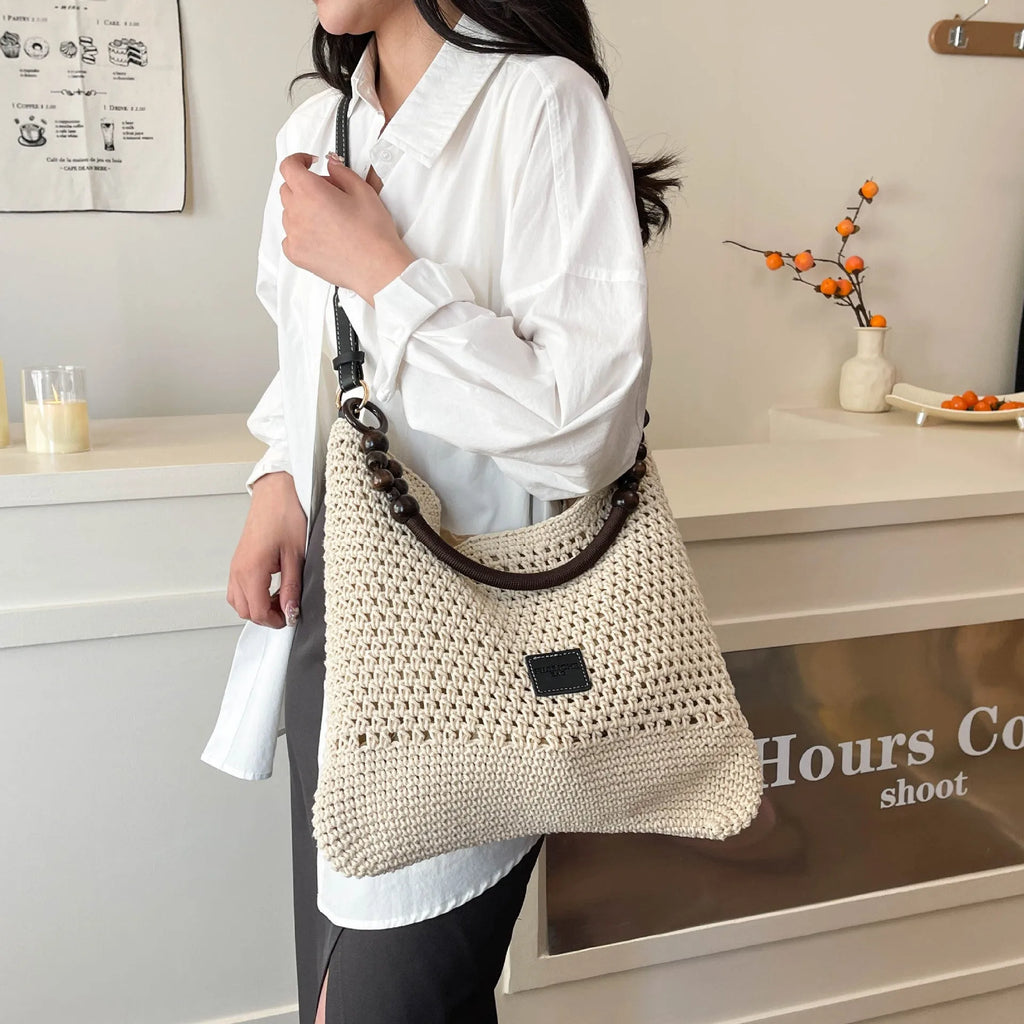 Knitted tote beach bag showing bucket shape, contrast stitching, and zippered internal pocket in black colour