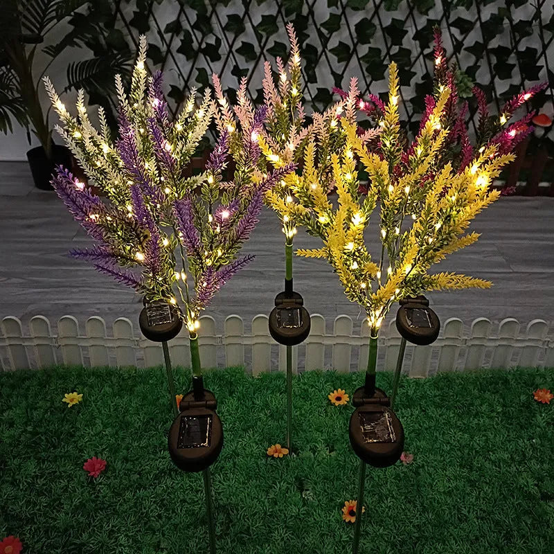 74cm tall pink lavender-shaped solar garden light with green stem, placed in a garden bed.