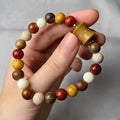 Brown coffee bean bracelet with wood piece and coconut shell geometric design on white background