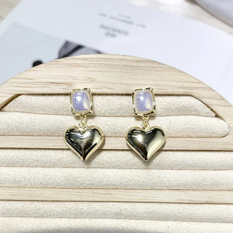 Small gold heart earrings with metal construction and post backing