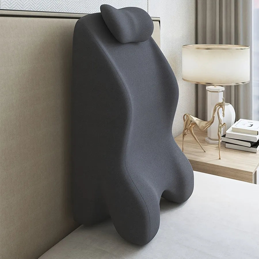 A blue stomach sleeper pillow on a bed, designed for lying face down.