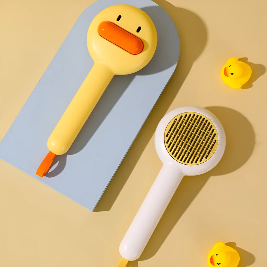Small yellow duck-shaped pet grooming comb with open sections and needle teeth