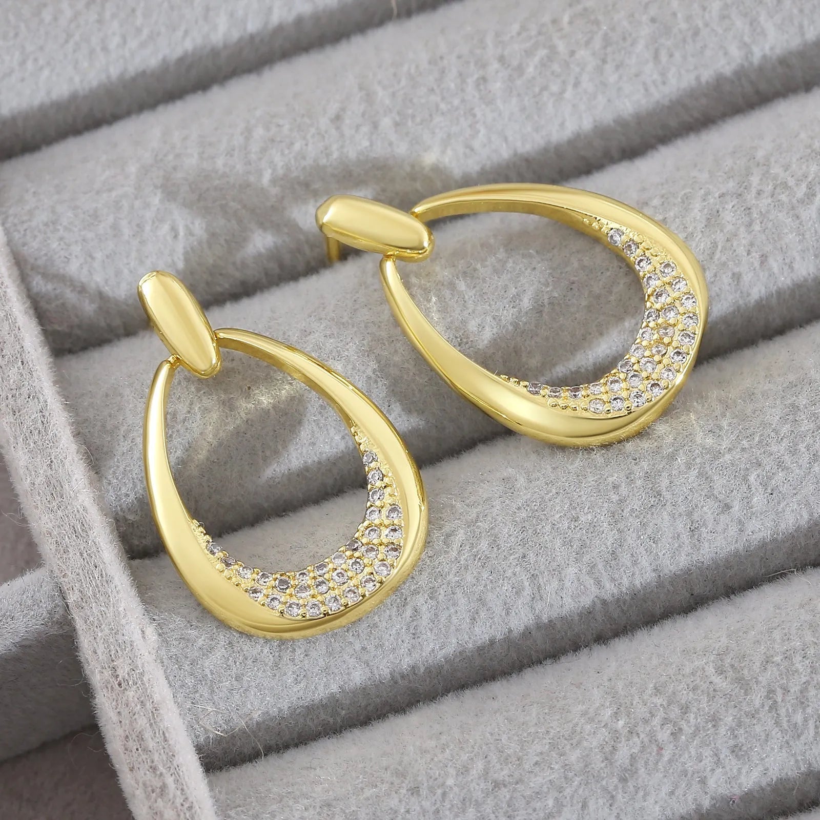Yellow gold geometric women's drop earrings with a ring design and zircon detail on a white background.