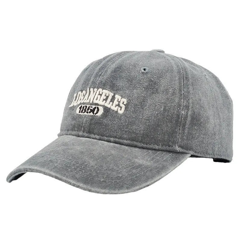 Retro-style adjustable acrylic peaked cap with embroidered letters, shown in a distressed beige colour.