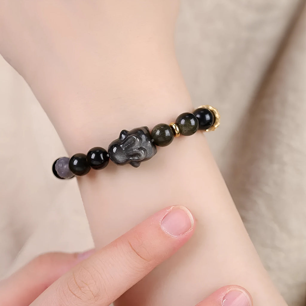 Handmade national style bracelet with a lying rabbit charm, grey agate, and metal details on a wrist.