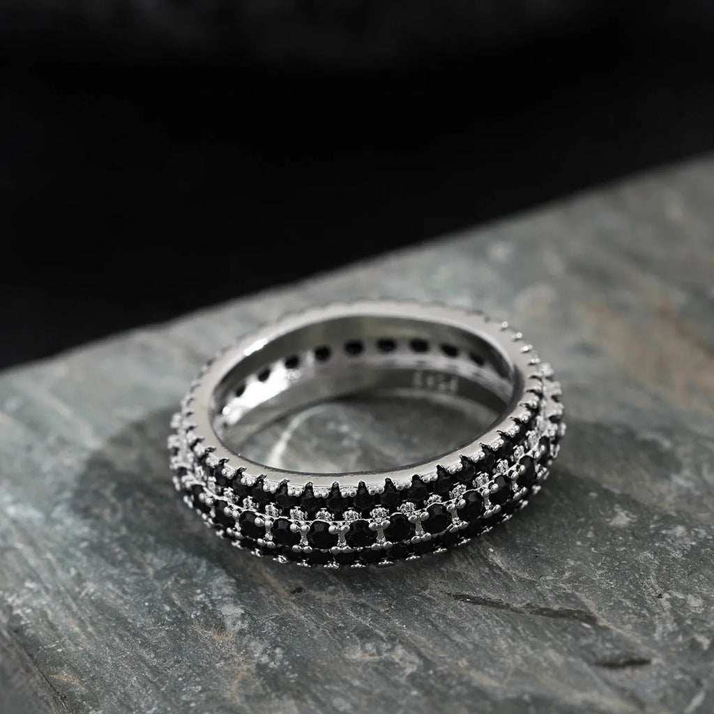 Geometric triangular ring with a zircon stone inlay, shown in white gold, yellow gold, and white and black finishes.
