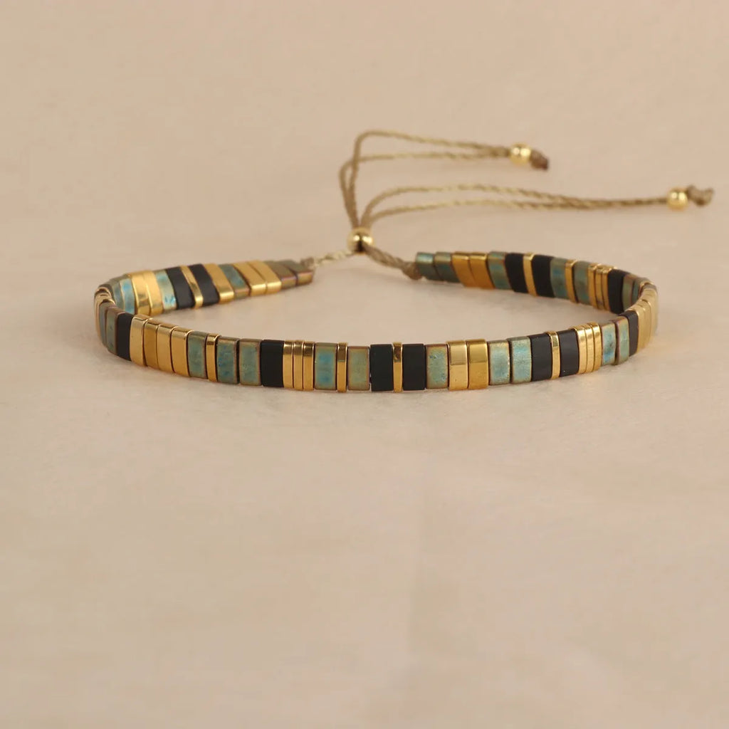 Geometric glass and coloured glaze beaded bracelet with a pull clasp in milky white colour.