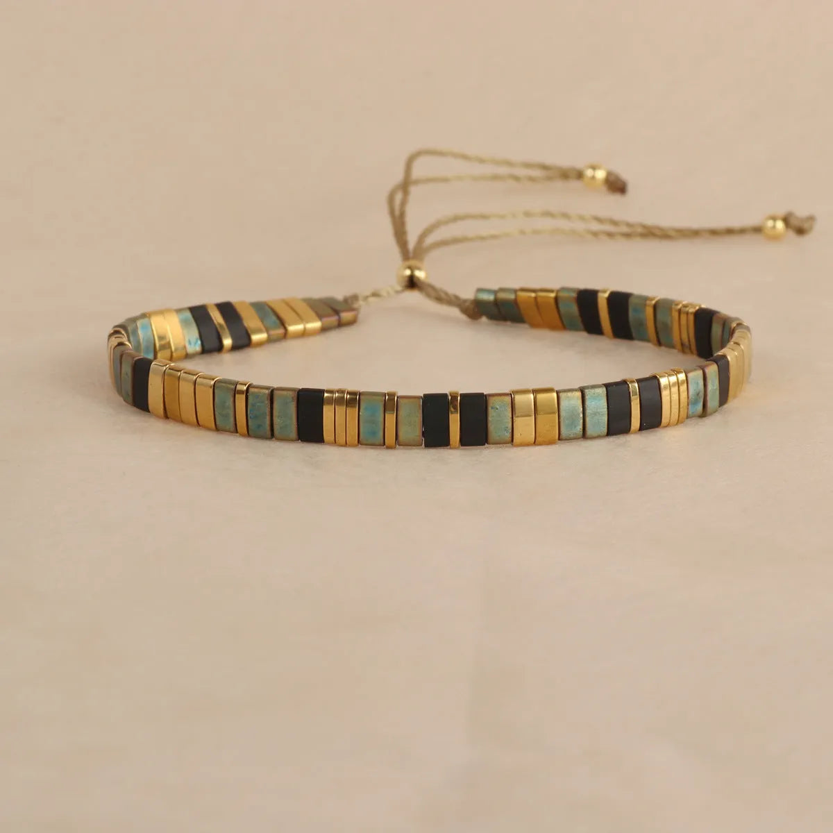 Geometric glass and coloured glaze beaded bracelet with a pull clasp in milky white colour.