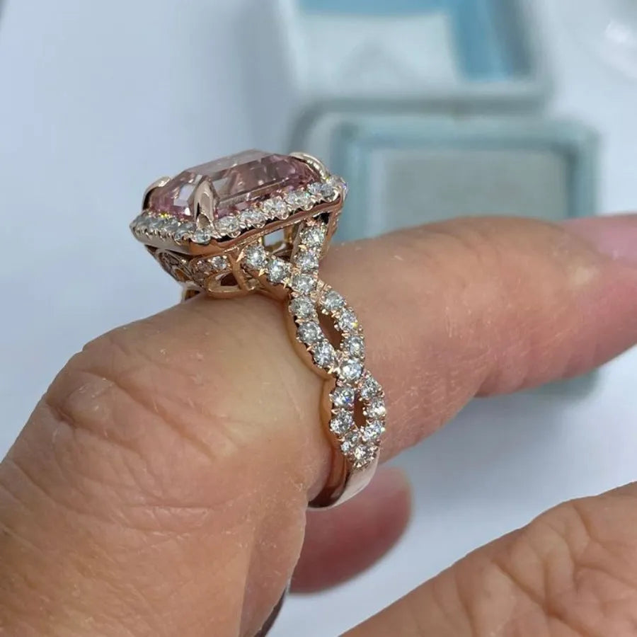 Rose gold geometric alloy ring on a plain background, showing its electroplated finish.