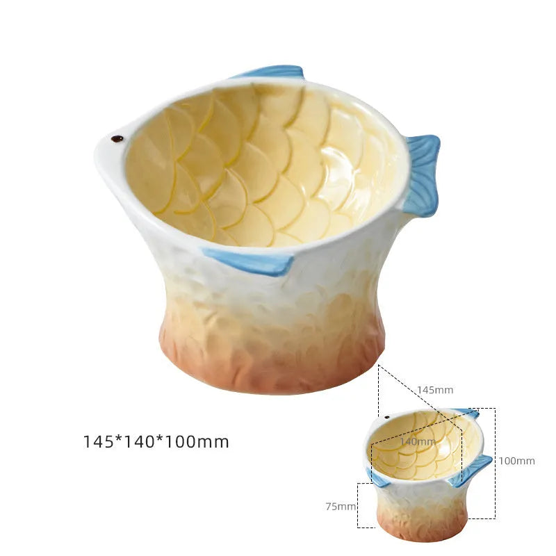 Blue ceramic cat food bowl in a fish shape with a tilted, elevated design and non-slip base.
