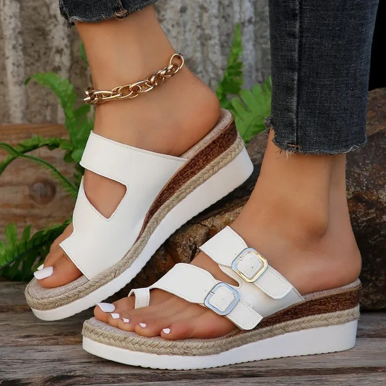 White woven patent leather wedge sandals with a peep toe and finger-fit strap design.