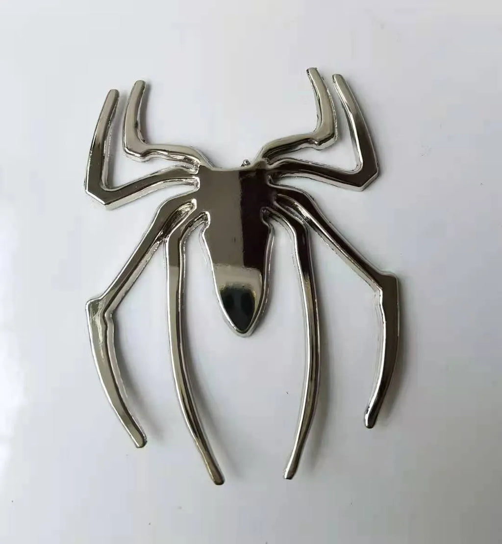Three-dimensional metal spider bumper sticker in zinc alloy, showing gold colour option.