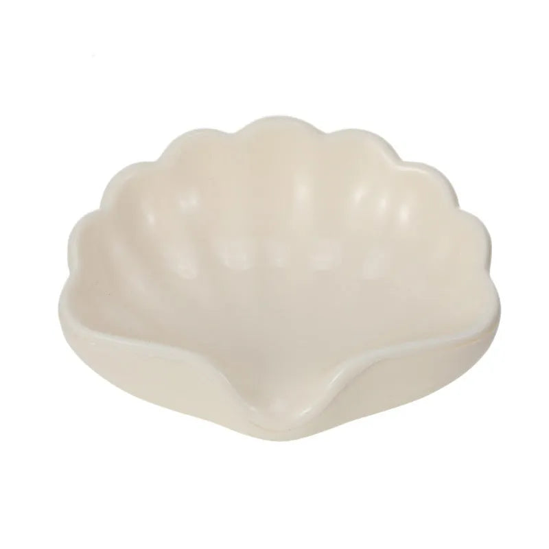 White and pink plastic shell-shaped soap dish for bathroom counter.