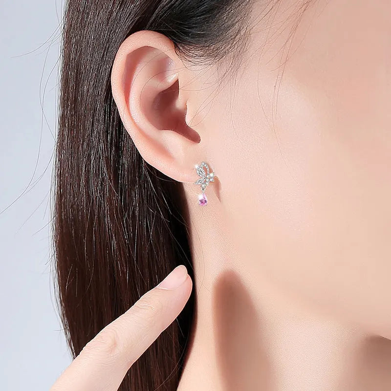 A pair of silver stud earrings with a faceted crystal butterfly design on a post backing.