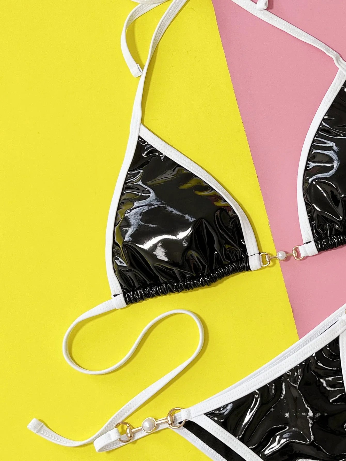 Black women's split bikini swimsuit with matching bra and briefs on solid background