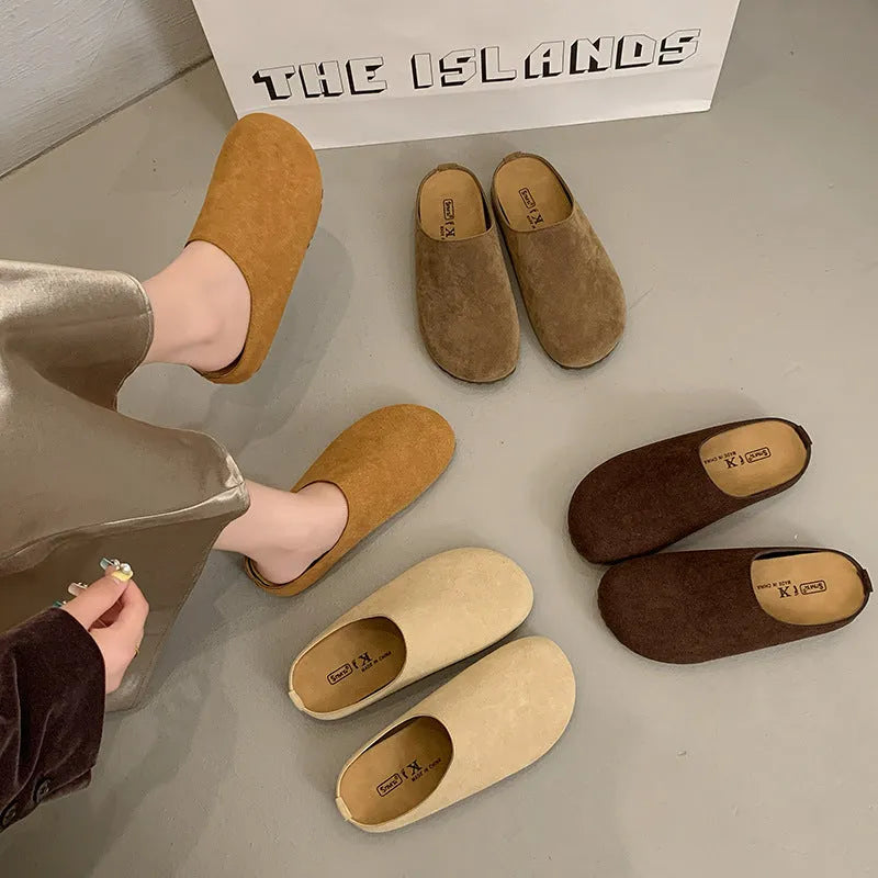 A pair of soft, flat apricot-coloured slip-on slippers with a square toe and microfiber upper on a plain background.