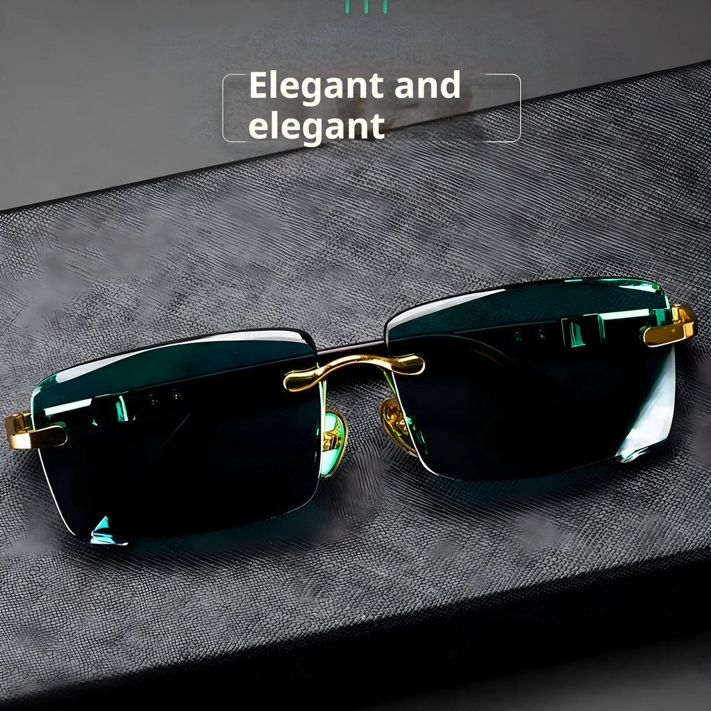 Dark green frameless crystal sunglasses with a matching case and cleaning cloth on a table.