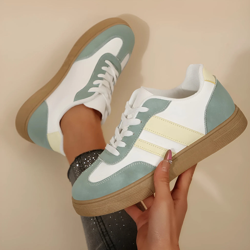 Green women's retro sports pumps with cross straps, flat rubber sole, and round toe on a white background.