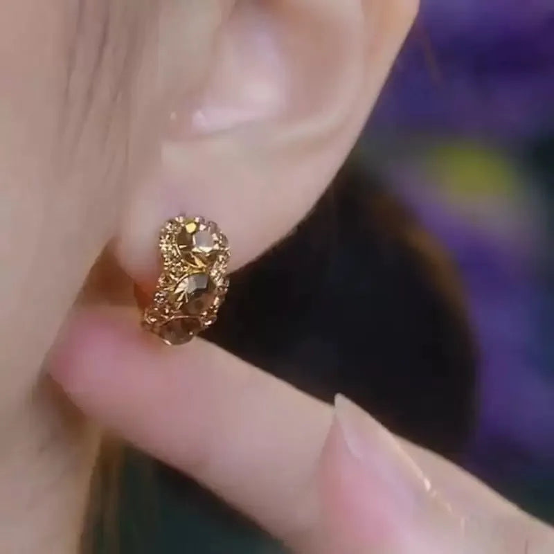 Gold metal hoop earrings with diamond surface treatment and brown zircon stones