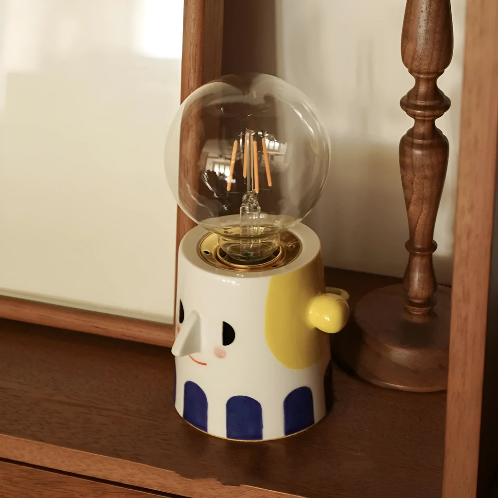 Handmade ceramic bedside lamp with ball headlight design on wooden nightstand