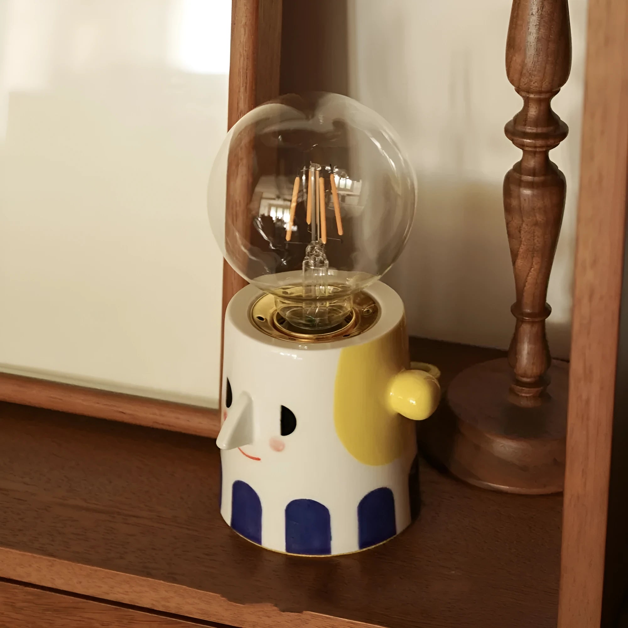 Handmade ceramic bedside lamp with ball headlight design on wooden nightstand