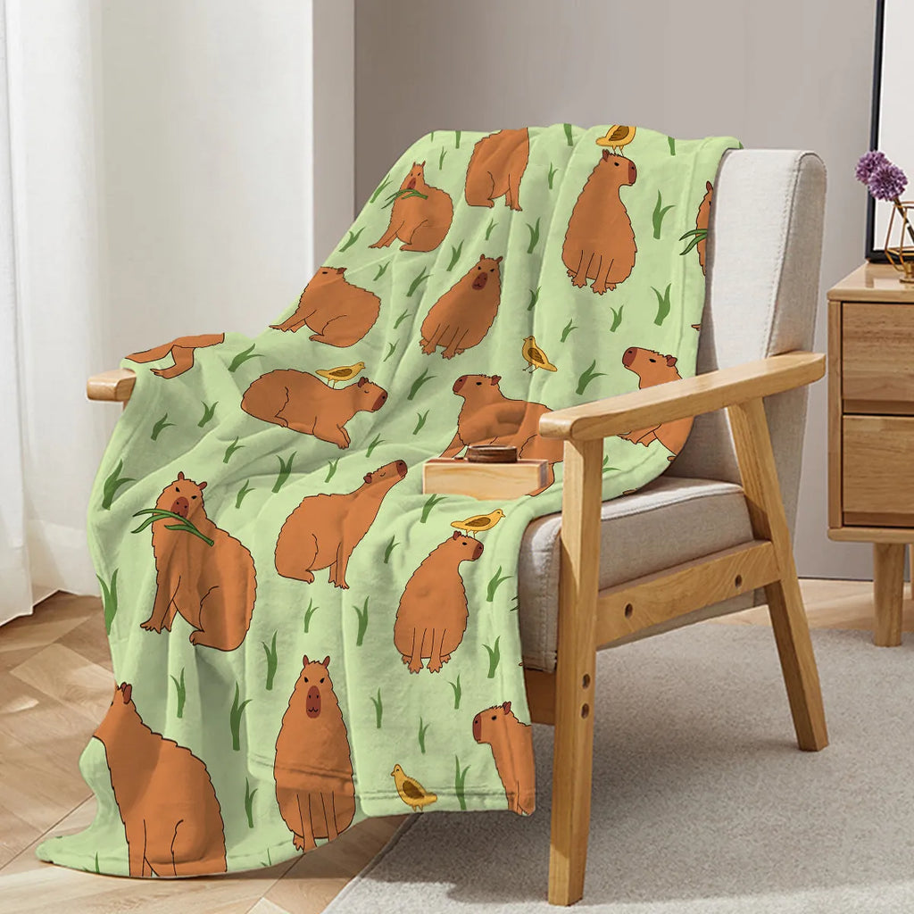 Multicolored flannel blanket with bird and capybara combined pattern on a sofa