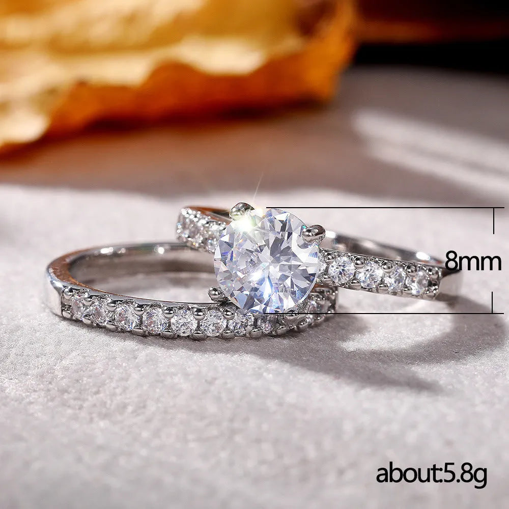 Two matching copper couple rings with a white gold finish and a small zircon stone inlay on a white background